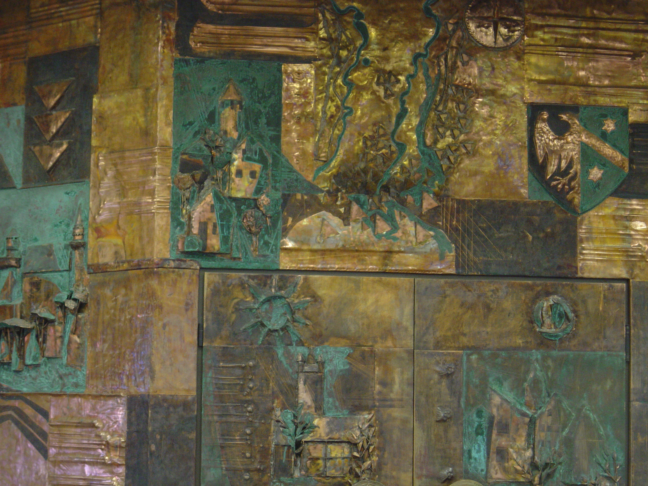 Das Bild zeigt ein Detail der von Arnulf Heimhofer gestalteten Eingangshalle der ehemalige AOK Kaufbeuren. Es handelt sich dabei um eine Kupferarbeit mit farblicher Bearbeitung.
